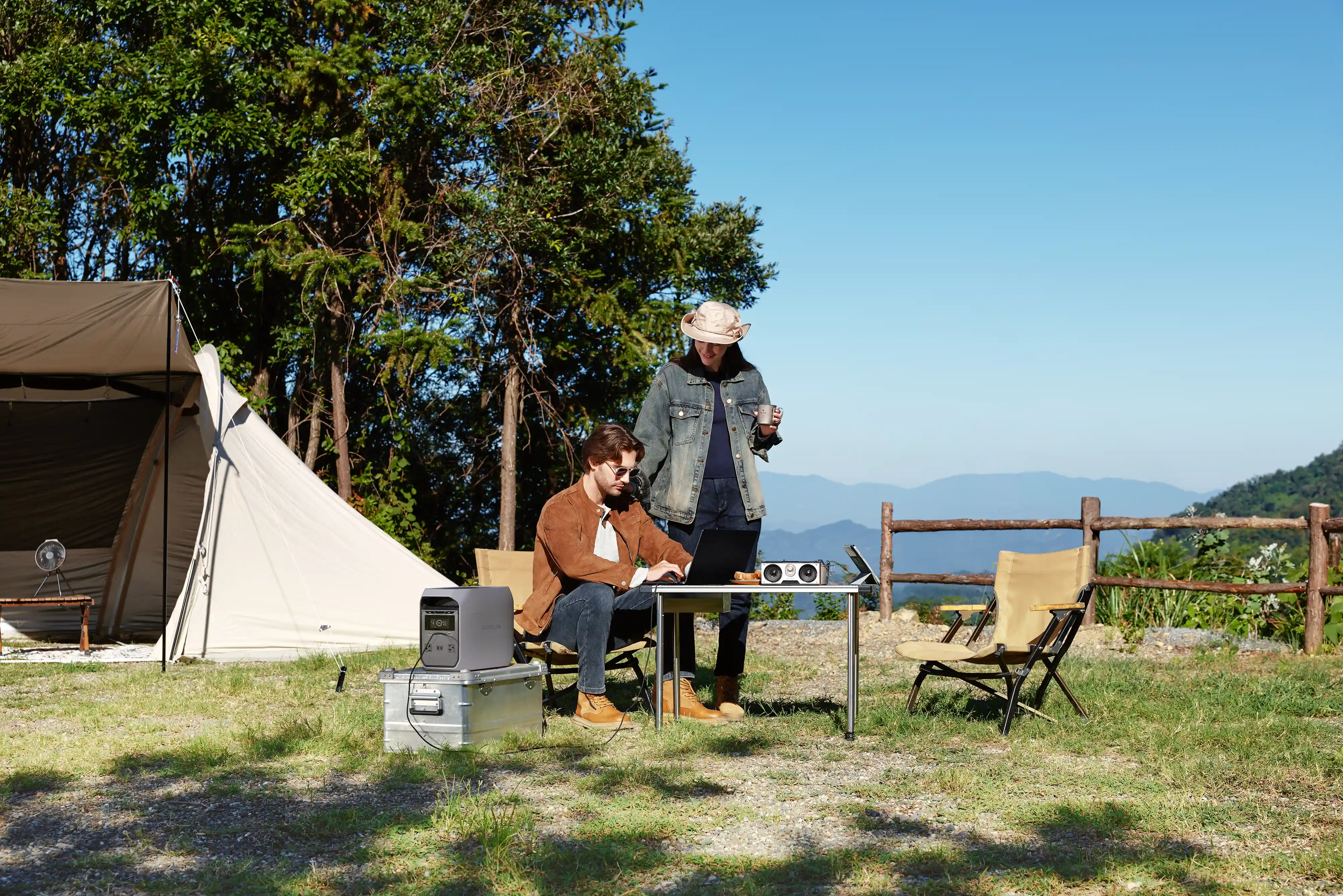 EcoFlow Delta 3 Classic power station supporting outdoor work at a mountain campsite, powering a laptop, speaker, and fan for a couple.