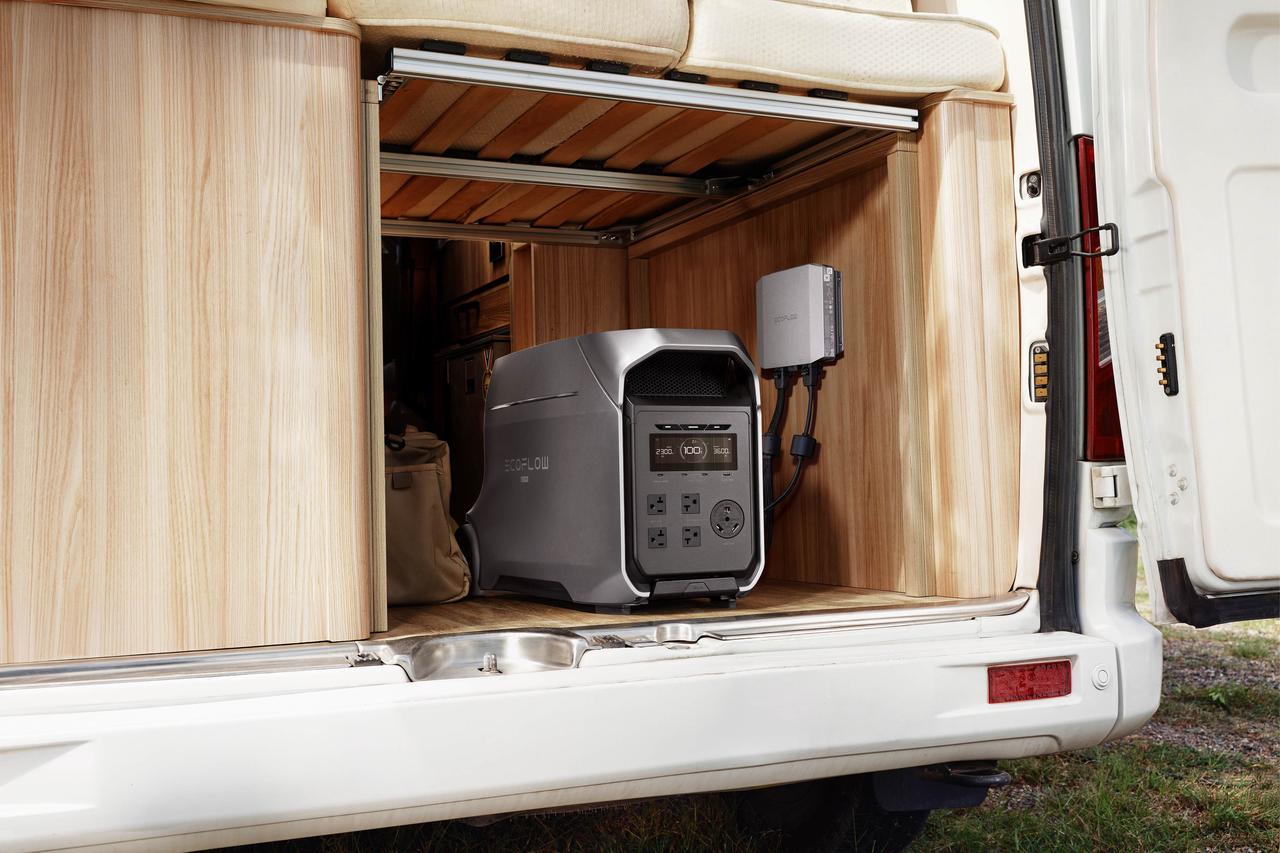Wide lifestyle shot of EcoFlow DELTA 3 Ultra Plus power station neatly stored in rear wooden cabinet of white camper van, matching wall connection module for RV road trip off-grid backup power