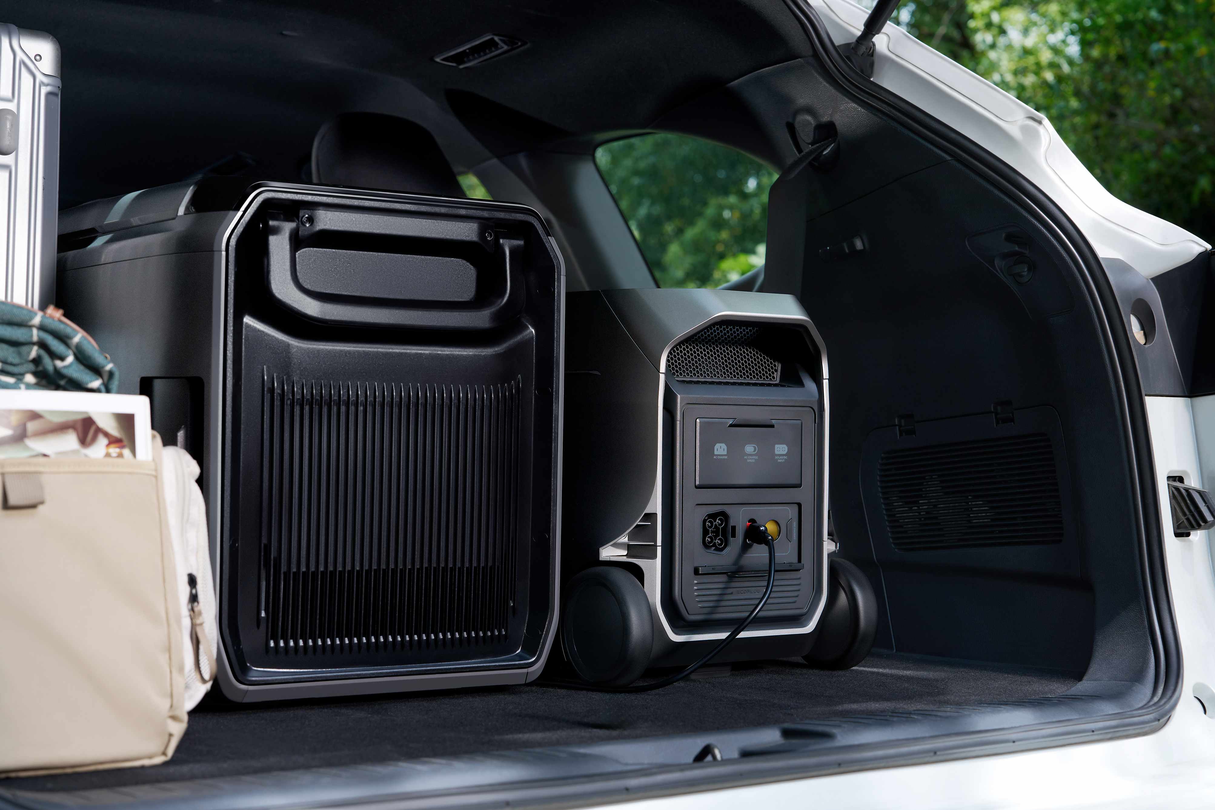 EcoFlow DELTA 3 Ultra portable power station placed in car trunk next to portable outdoor air conditioner, expandable off-road camping energy storage kit for road trips