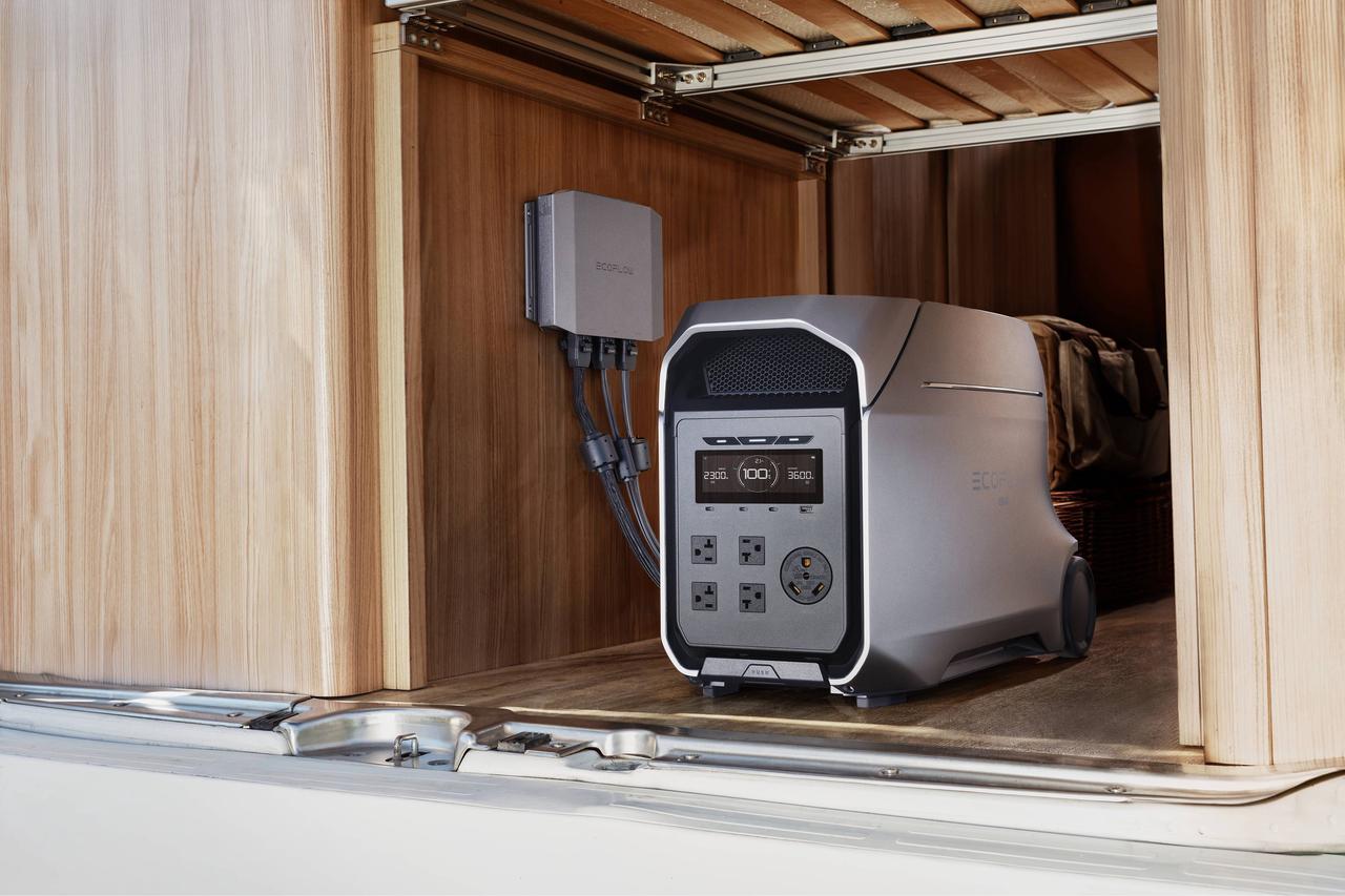 Close-up shot of EcoFlow DELTA 3 Ultra built-in RV power system with wall hardwiring module inside wooden camper cabinet, LCD screen and multi AC outlets visible