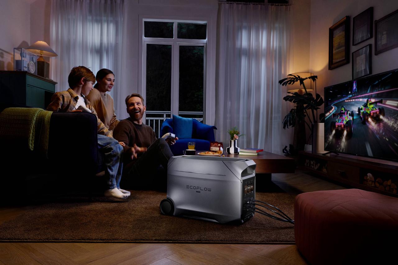 Whole family playing racing video games on TV powered by EcoFlow DELTA 3 Ultra Plus with built-in wheels, reliable home backup battery keeps entertainment and daily electronics running amid grid outages.
