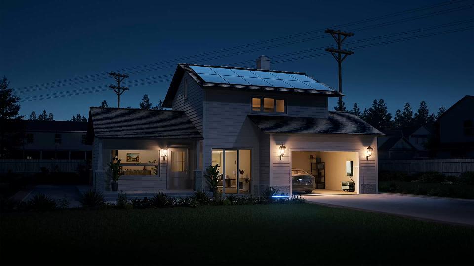 Suburban two-story house with rooftop solar panels, EcoFlow DELTA Pro Ultra whole-house battery backup installed inside garage at night